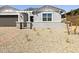 Well-maintained front yard with decorative rock landscaping and a young tree, offering curb appeal at 4032 S 176Th Dr, Goodyear, AZ 85338