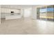 Living room with an open layout leading to the kitchen, tile flooring, and a sliding glass door to the patio at 4032 S 176Th Dr, Goodyear, AZ 85338