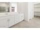 Bright bathroom with dual sinks, white cabinetry, walk-in closet, and large mirrors for a sleek look at 4032 S 176Th Dr, Goodyear, AZ 85338