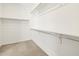 Well-organized walk-in closet with ample shelving, rods, and neutral carpet, ideal for storage at 4032 S 176Th Dr, Goodyear, AZ 85338
