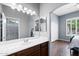Bright bathroom with large mirror, vanity, and open doorway leading to a bedroom at 5744 E Hedgehog Pl, Scottsdale, AZ 85266