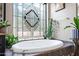 Relaxing bathtub with decorative privacy window and stylish tile surround at 5744 E Hedgehog Pl, Scottsdale, AZ 85266