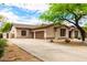 Side view of home with 3-car garage featuring a large driveway and desert landscaping at 5744 E Hedgehog Pl, Scottsdale, AZ 85266