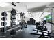 Well-equipped garage gym with weight racks, lockers, and various fitness machines on rubber flooring at 5744 E Hedgehog Pl, Scottsdale, AZ 85266
