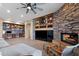 Comfortable living room with a stone fireplace, custom built-ins, and an open layout at 5744 E Hedgehog Pl, Scottsdale, AZ 85266