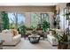 Cozy living room featuring natural light, stylish sofas, and views of outdoor foliage at 5744 E Hedgehog Pl, Scottsdale, AZ 85266