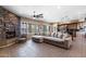 Bright living room with a stone fireplace, tile flooring, and open layout to the kitchen at 5744 E Hedgehog Pl, Scottsdale, AZ 85266