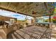 A covered outdoor kitchen includes a built in grill and seating overlooking a pool at 5744 E Hedgehog Pl, Scottsdale, AZ 85266