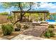 A covered outdoor cooking area overlooks a backyard pool with a water feature at 5744 E Hedgehog Pl, Scottsdale, AZ 85266