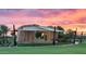 An outdoor stage featuring a beige and tan concrete shell with a stretched fabric awning, surrounded by green grass at sunset at 10203 E Revolution Dr, Mesa, AZ 85212