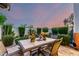 Relaxing backyard with a table for outdoor dining, lush greenery, and a beautiful evening sky at 11011 N 92Nd St # 1010, Scottsdale, AZ 85260