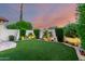 Tranquil backyard with manicured lawn, lush greenery, mature trees and landscape lighting at 11011 N 92Nd St # 1010, Scottsdale, AZ 85260