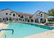 Resort-style pool area with comfortable lounge chairs in a community of white buildings under a clear blue sky at 11011 N 92Nd St # 1010, Scottsdale, AZ 85260