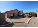 Desert landscaped backyard with a patio area and a sliding glass door entrance at 14912 W Lamoille Dr, Surprise, AZ 85374