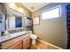A cozy bathroom with wood cabinets, updated hardware, and tile floors at 14912 W Lamoille Dr, Surprise, AZ 85374