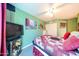 A colorful bedroom with green walls, wood floors, and a large window at 14912 W Lamoille Dr, Surprise, AZ 85374