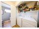 The laundry room has white appliances, shelving, and tile floors at 14912 W Lamoille Dr, Surprise, AZ 85374