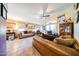 Bright living room with tile floors, ceiling fan, and sliding glass doors to the backyard at 14912 W Lamoille Dr, Surprise, AZ 85374