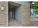 Covered entryway featuring brick accents, modern lighting, and a stylish front door at 16140 W Sierra St, Surprise, AZ 85379