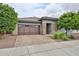 Inviting single-story home with brick accents, landscaped yard, and a paved driveway at 16140 W Sierra St, Surprise, AZ 85379