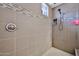 Close up of tiled walk-in shower featuring a showerhead, built-in niche, and bench at 16140 W Sierra St, Surprise, AZ 85379