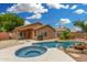 Beautiful backyard features a sparkling pool with rock accents and a connected in-ground hot tub, perfect for relaxing at 1905 E Palomino Dr, Gilbert, AZ 85296