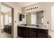 Bathroom featuring granite countertops, dual sinks, and a large mirror at 1905 E Palomino Dr, Gilbert, AZ 85296