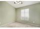 A serene bedroom with neutral carpet, a ceiling fan, and a window at 1905 E Palomino Dr, Gilbert, AZ 85296