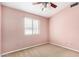 Comfortable bedroom features neutral carpet, a ceiling fan, and window for natural light at 1905 E Palomino Dr, Gilbert, AZ 85296