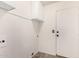 Bright laundry room with white walls, overhead cabinet, and a door to the exterior at 1905 E Palomino Dr, Gilbert, AZ 85296
