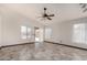 Airy living room with tile flooring, neutral walls, a ceiling fan, and natural light from adjacent pool access at 1905 E Palomino Dr, Gilbert, AZ 85296