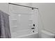 Bright white bathtub with black fixtures and shower head, complemented by a gray towel on a bar at 20209 W San Miguel Ave, Litchfield Park, AZ 85340