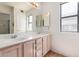 Bathroom features double sink vanity, a large mirror, and natural light from a window at 2039 W Ronald Rd, Phoenix, AZ 85029