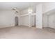 Spacious living room with carpet flooring, ceiling fan, and archway to additional living space at 2039 W Ronald Rd, Phoenix, AZ 85029