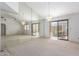 Bright and airy living room with large mirrored wall, sliding glass doors, and neutral carpet at 2039 W Ronald Rd, Phoenix, AZ 85029