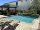 Beautiful backyard pool with covered outdoor living space and stone water feature, perfect for enjoying sunny days at 2087 N Park St, Buckeye, AZ 85396