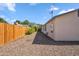 Long, narrow backyard lined with a wooden fence, gravel, and a side view of the home at 2726 E Fairmount Ave, Phoenix, AZ 85016