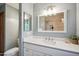 Bathroom vanity featuring a white countertop, white sink, framed mirror, and view of the tiled shower at 2726 E Fairmount Ave, Phoenix, AZ 85016