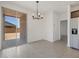 Open dining area with modern chandelier, backyard access, and stainless steel refrigerator at 322 S San Christo Ln, Casa Grande, AZ 85194