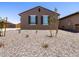 A cozy single-story home featuring minimal desert landscaping, a brown exterior, and shuttered windows at 322 S San Christo Ln, Casa Grande, AZ 85194