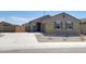 Welcoming single-story home with a spacious driveway, desert landscaping, and charming shuttered windows at 322 S San Christo Ln, Casa Grande, AZ 85194