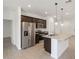 Modern kitchen with stainless steel appliances, granite counters, and dark cabinets with pendant lights at 322 S San Christo Ln, Casa Grande, AZ 85194