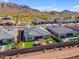 Aerial view of several homes in a desert community, landscaped backyards, and mountain views at 3466 E Hazeltine Way, Queen Creek, AZ 85142