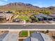 Aerial view showcasing a desert neighborhood with a community park, lush greenery, and mountain views at 3466 E Hazeltine Way, Queen Creek, AZ 85142