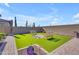 Entertaining backyard with artificial turf, checkerboard, and charming benches at 3466 E Hazeltine Way, Queen Creek, AZ 85142