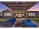 Stunning backyard featuring a pergola, outdoor seating, and well-maintained artificial grass at 3466 E Hazeltine Way, Queen Creek, AZ 85142