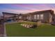 Dusk view of a backyard featuring artificial turf, benches, and a checkerboard game at 3466 E Hazeltine Way, Queen Creek, AZ 85142