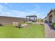 Large backyard with artificial turf, checkerboard, pergola, and outdoor seating area at 3466 E Hazeltine Way, Queen Creek, AZ 85142