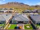 An aerial view of a beautiful backyard featuring artificial turf, a pergola, and lush desert surroundings at 3466 E Hazeltine Way, Queen Creek, AZ 85142