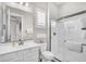 Clean bathroom with white cabinets, a walk-in shower with glass doors, and a large vanity mirror at 3466 E Hazeltine Way, Queen Creek, AZ 85142